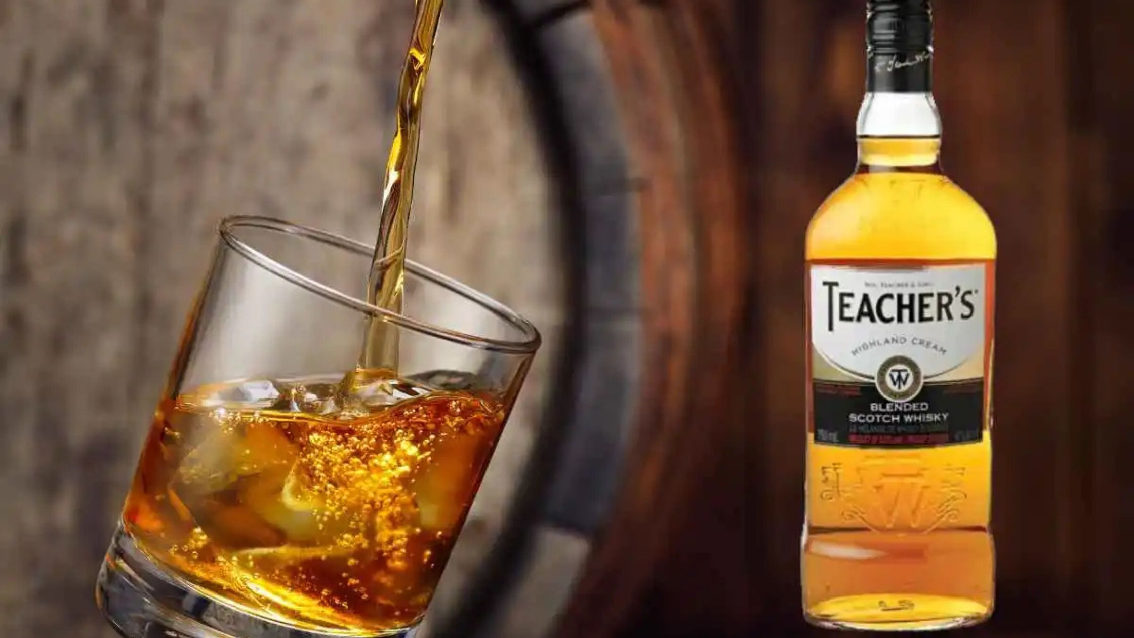 A glass of whisky being poured with a bottle of Teacher's Highland Cream Blended Scotch Whisky in the background